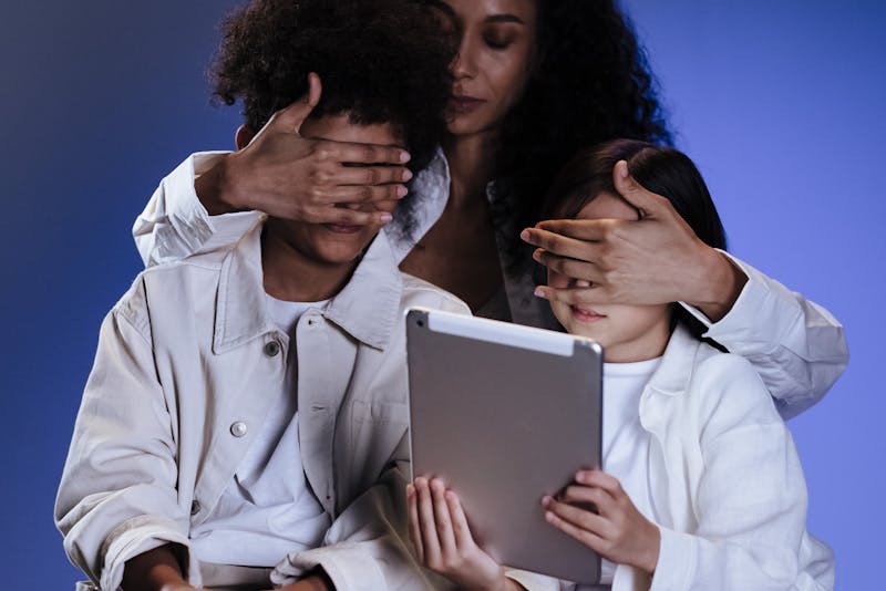 a mother keeping her kids from seeing the tablet screen